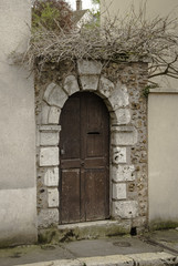 old weathered wooden doorway with dried branches above