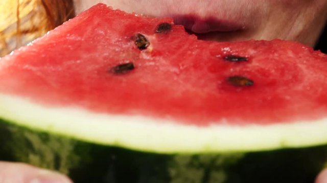 Closeup of mature woman eating fresh red watermelon fruit. Healthy food organic nutrition. 4K ProRes HQ codec