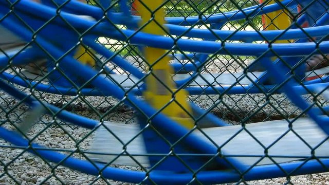 Enfants sur une balan&ccedil;oire bleue dans un parc d'attraction