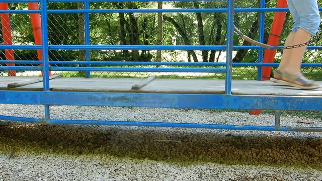 Enfant jouant sur une grande balançoire dans un parc d'attraction