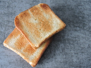 Two wheat toast on a gray background