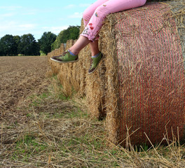 woman's legs country girl on rural straw bales