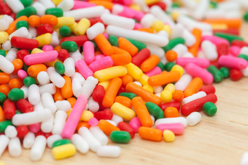 colorful rainbow sprinkles on wooden plate