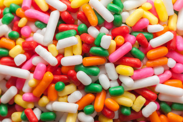 colorful rainbow sprinkles on wooden plate