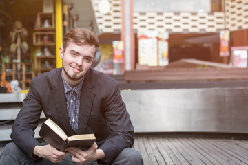 Closeup on a man reading a bible at shopping mall, believe concept