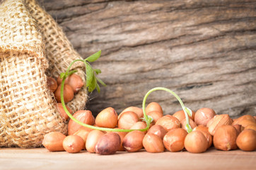 Peanut in burlap bag on old wooden background, close up ,concept of healthy protein power,select focus