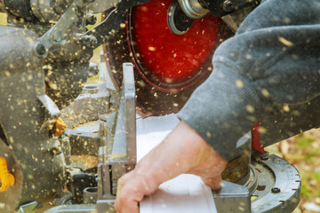 Man, worker sawing wood with a circular saw, machine for cutting.