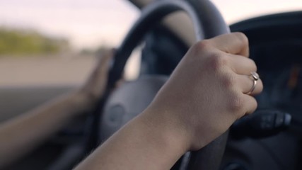 Slow Motion Closeup Of Young Woman's Hands On Steering Wheel, Driving On Freeway