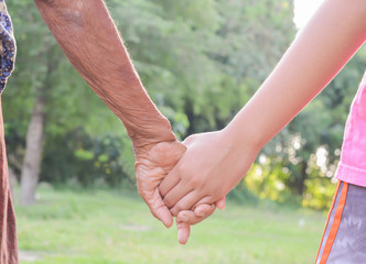 Hand,old and children's hand with light of the evening.