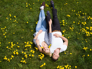 man and woman lying on the grass