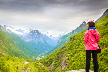 Fototapeta na wymiar Tourist with camera taking picture in mountains Norway