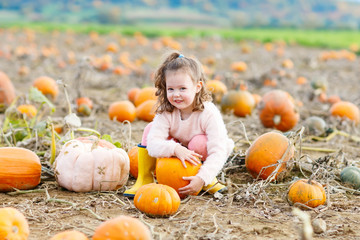 little girl farming on pumpkin patch