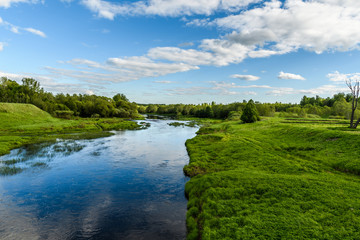 Fototapeta na wymiar The bend of the river Shelon in the Pskov region, in the daytime, more of the sky all in the blue green spectrum