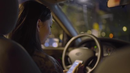 Distracted Driver Checks Her Smart Phone At A Red Light, Train Passes By Her Window On Right