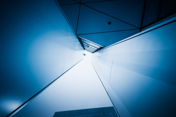 Low angle view of abstract building ceiling in blue tone.