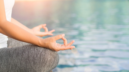 Closeup woman yoga finger acting on hands in soft focus background with nature surrounding. Concept of healthy lifestyle and relaxation.