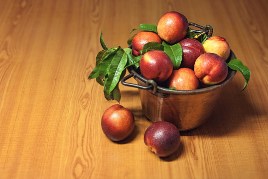 Fresh peaches fruit with leaves in old tray