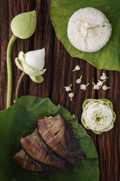 thai food rice and dried salted damsel fish fried with flower lotus jasmine decoration on wooden background