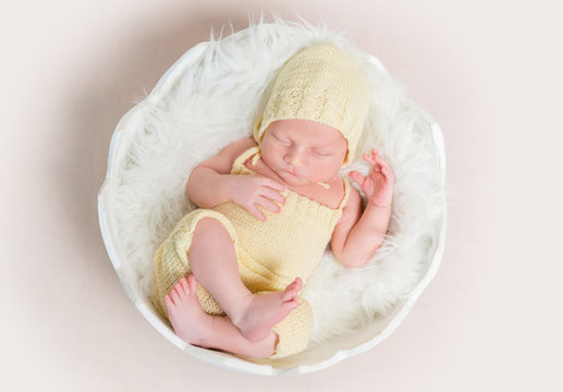 sweet newborn baby in hat and panties sleeping on the shell