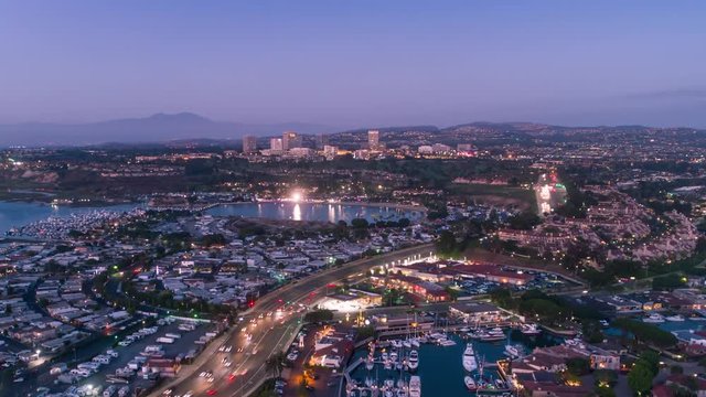 Urban aerial timelapse in motion or hyperlapse at twilight or PCH traffic with city skyline in Newport Beach