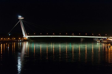 Night view of the lighted SNP bridge over Danube river in capital city Bratislava, Slovakia