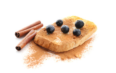 Tasty cinnamon toast with blueberries on white background