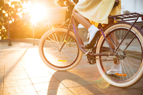 Cropped image of a young female in dress riding bicycle