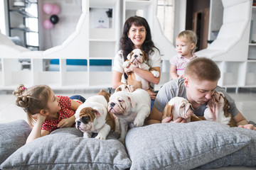 Family of four lying on the carpet with puppies