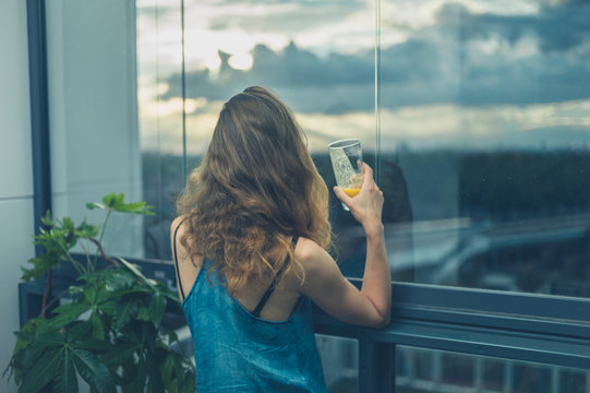 Woman on balcony drinking juice