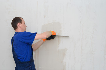 Plastering shpatlyuet wall with a spatula and white putty