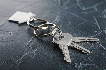 estate concept with key, keychain with house symbol, stone background