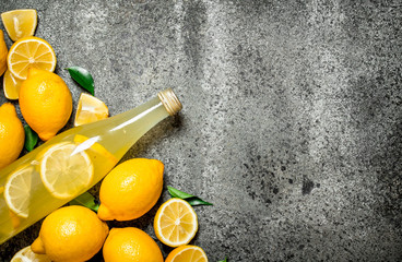Lemonade in the bottle with slices of fresh lemons.