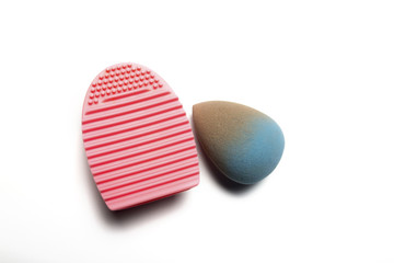 Used makeup sponge and rubber cleaner on a white background