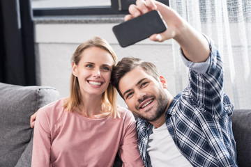 Fototapeta na wymiar couple taking selfie on smartphone