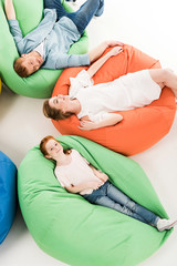 Obraz premium parents with daughter on bean bag chairs