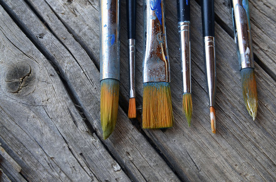 Paint brushes on old wooden background.Set of artistic paintbrushes.Brushes for painting on a rustic table.Selective focus.