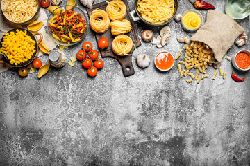 Pasta background. Pasta with sauces, vegetables and olive oil.