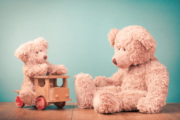 Big and small Teddy Bears, old retro toy wooden truck. Vintage style filtered photo