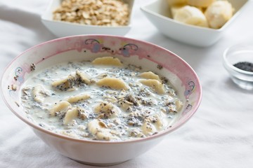 Breakfast dish of oatmeal, banana, milk and poppy seeds