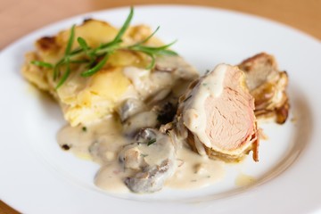Pork tenderloin in bacon with potatoes and mushroom sauce