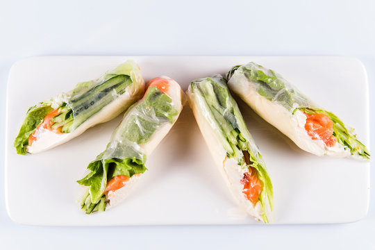 Rolls of rice paper with vegetables and seafood on white background isolated. Traditional Japanese cuisine