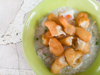 Traditional thai porridge rice gruel in white bowl congee. In the street market