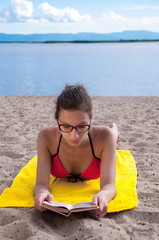 Girl on the beach reading a book