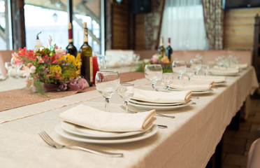 Table setting, selective focus. Table served for wedding banquet, close up view. Beige serviette on white empty plate on dinner table