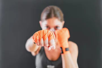 Foto auf Acrylglas Kampfkunst Power Female Punching With Boxing Bandage