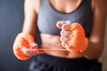 Abwaschbare Fototapete Kampfkunst Female Hands Wearing Boxing Bandages