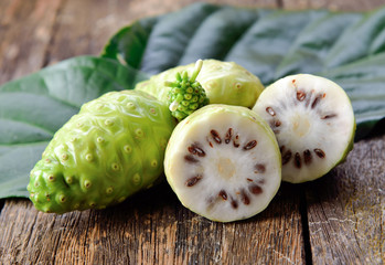 noni fruit on wooden background