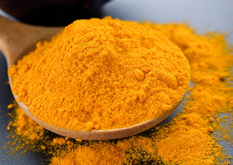 Turmeric powder on black background.