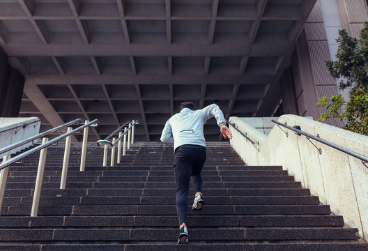 Back view of man running up the stairs