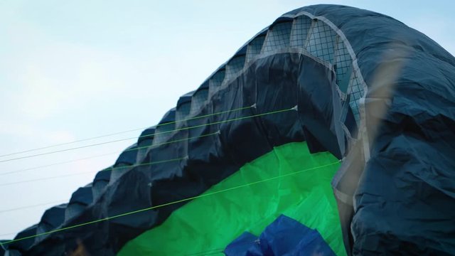 hang glider flying over a field. The wing of the paraglider lies on the ground in the steppe. Soon they will take off. Feeling of freedom and a sense of flying. The beginning of adventure. Paraplane.